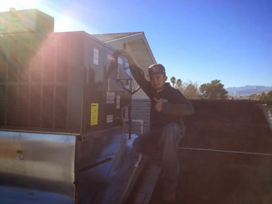 HVAC technician performing Air Duct Cleaning on a rooftop unit in Jasper
